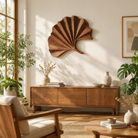 Fan shaped leaf wall art with carved radiating ridges and a curled stem in a bright sunroom with green plants