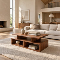 Coffee table with a raised slab top over two open cubbies in a bright open plan living room