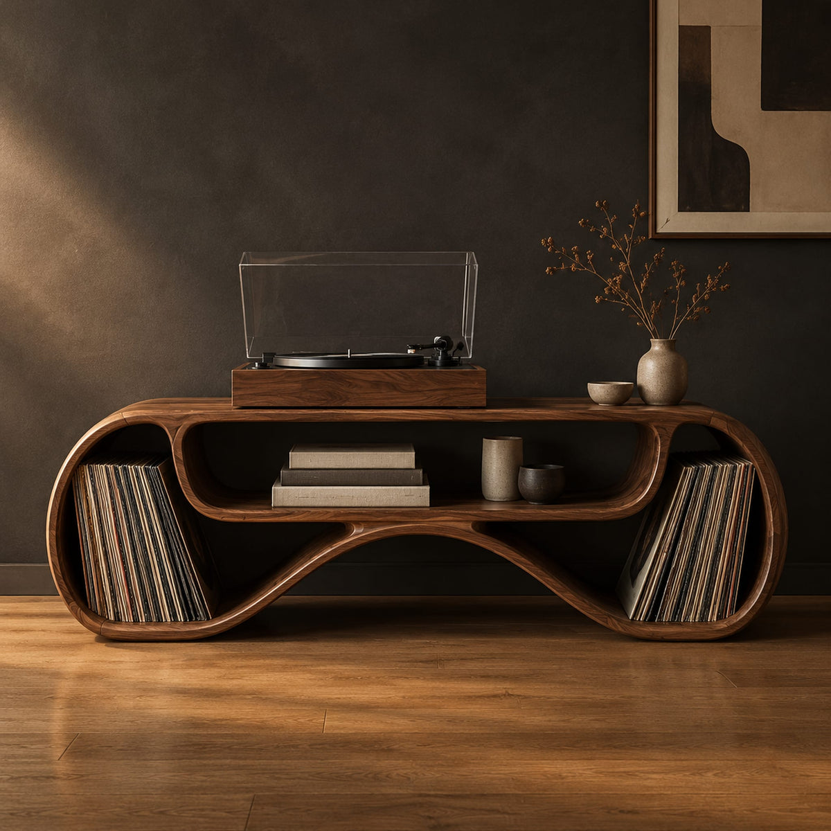 Long low record console with rolled ends and a wave shaped lower edge in a dark studio against a charcoal plaster wall