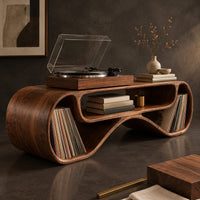 Corner detail of long low record console with rolled ends and a wave shaped lower edge beside wood, brass and linen samples