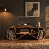 Long low record console with rolled ends and a wave shaped lower edge in a dark living room at golden hour