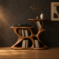 Sculpted organic record player stand with open pockets and two top levels in a dark studio against a charcoal plaster wall
