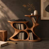 Corner detail of sculpted organic record player stand with open pockets and two top levels beside wood, brass and linen samples