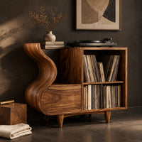 Corner detail of record player stand with a flowing wave side and two open cubbies beside wood, brass and linen samples