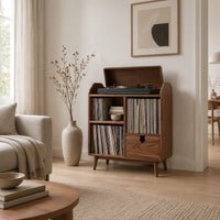 Wood record player stand on tapered legs with open cubbies and a drawer in a Scandinavian living room with white walls