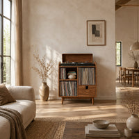 Wood record player stand on tapered legs with open cubbies and a drawer in a bright open plan living room