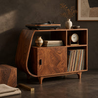Corner detail of record player stand with a teardrop shaped side, a wood door and tapered legs beside wood, brass and linen samples