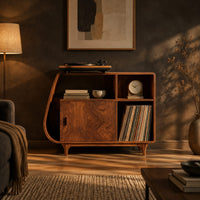 Record player stand with a teardrop shaped side, a wood door and tapered legs in a dark living room at golden hour