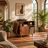 Record player stand with a teardrop shaped side, a wood door and tapered legs in a bright living room with arched windows and plants
