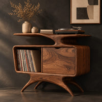 Corner detail of record player stand with a winged top shelf, open bay and splayed legs beside wood, brass and linen samples