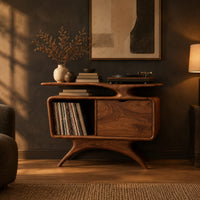 Record player stand with a winged top shelf, open bay and splayed legs in a dark living room at golden hour