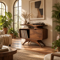 Record player stand with a winged top shelf, open bay and splayed legs in a bright living room with arched windows and plants