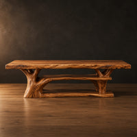 Rectangle dining table on a branching tree trunk base in a dark studio against a charcoal plaster wall
