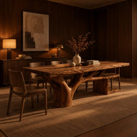 Rectangle dining table with a thick slab top and a branching trunk base in an evening dining room with walnut wall paneling
