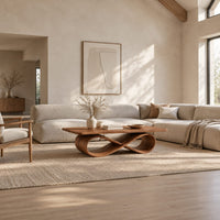 Rectangular wooden coffee table on a figure eight ribbon base in a bright open plan living room
