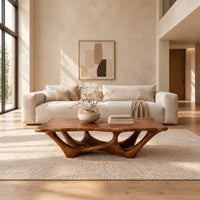 Rectangular coffee table with a slab top and branching arched base in a bright open plan living room