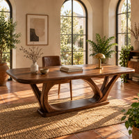 Rectangular desk on arched loop legs joined by a flat wood base in a bright home office with arched windows and plants