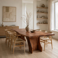 Rectangular dining table with a thick slab top on a wide hourglass pedestal in a Scandinavian dining room with white walls