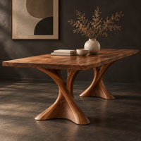 Corner detail of rectangular dining table on two hourglass pedestal legs beside wood, brass and linen samples