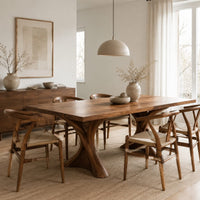 Rectangular dining table on two hourglass pedestal legs in a Scandinavian dining room with white walls