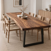 Rectangular wood table top slab with bold swirling grain and a thick edge in a Scandinavian dining room with white walls