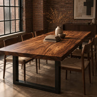 Rectangular wood table top slab with bold swirling grain and a thick edge in an industrial loft dining room with exposed brick