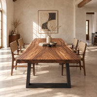 Rectangular wood table top slab with bold swirling grain and a thick edge in a bright open plan dining room