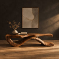 Low bench with a long slab seat on a flowing ribbon shaped base in a dark studio against a charcoal plaster wall