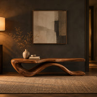 Low bench with a long slab seat on a flowing ribbon shaped base in a dark entryway at golden hour
