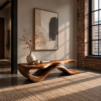 Low bench with a long slab seat on a flowing ribbon shaped base in an industrial loft entryway with exposed brick