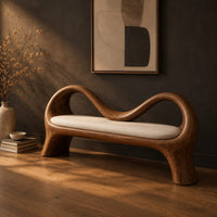 Bench with a wave shaped ribbon frame and a slim pale seat pad, three-quarter view showing the grain