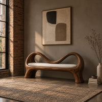 Bench with a wave shaped ribbon frame and a slim pale seat pad in an industrial loft entryway with exposed brick