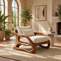 Lounge chair with a looping wooden ribbon frame and cream cushions in a bright living room with arched windows and plants