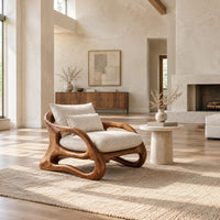 Lounge chair with a looping wooden ribbon frame and cream cushions in a bright open plan living room