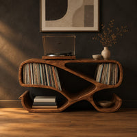 Ribbon frame record console with two open end bays and curled feet in a dark studio against a charcoal plaster wall