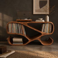 Corner detail of ribbon frame record console with two open end bays and curled feet beside wood, brass and linen samples
