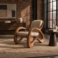 Upholstered chair with open loop arms and ribbon shaped wooden legs in an industrial loft living room with exposed brick