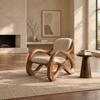 Upholstered chair with open loop arms and ribbon shaped wooden legs in a bright open plan living room