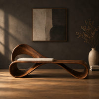 Ribbon loop bench with an arched backrest and a cream cushion in a dark studio against a charcoal plaster wall