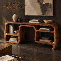 Corner detail of console table with looping ribbon sides and open cubbies on both ends beside wood, brass and linen samples