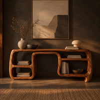 Console table with looping ribbon sides and open cubbies on both ends in a dark entryway at golden hour