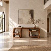 Console table with looping ribbon sides and open cubbies on both ends in a bright open plan entryway