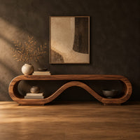 Low tv stand shaped as a rolling ribbon loop in a dark studio against a charcoal plaster wall