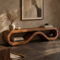 Corner detail of low tv stand shaped as a rolling ribbon loop beside wood, brass and linen samples