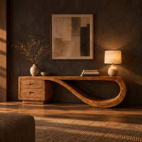 Low tv stand with two drawers and a ribbon shaped looping end in a dark living room at golden hour
