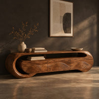 Wooden tv stand with a looping ribbon band and wave carved front panels, three-quarter view showing the grain