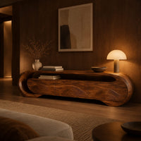 Wooden tv stand with a looping ribbon band and wave carved front panels in an evening living room with walnut wall paneling