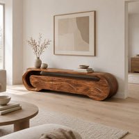 Wooden tv stand with a looping ribbon band and wave carved front panels in a Scandinavian living room with white walls