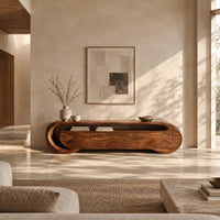 Wooden tv stand with a looping ribbon band and wave carved front panels in a bright open plan living room