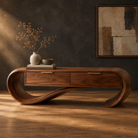 Looping wooden bench with a ribbon shaped frame and two drawers in a dark studio against a charcoal plaster wall